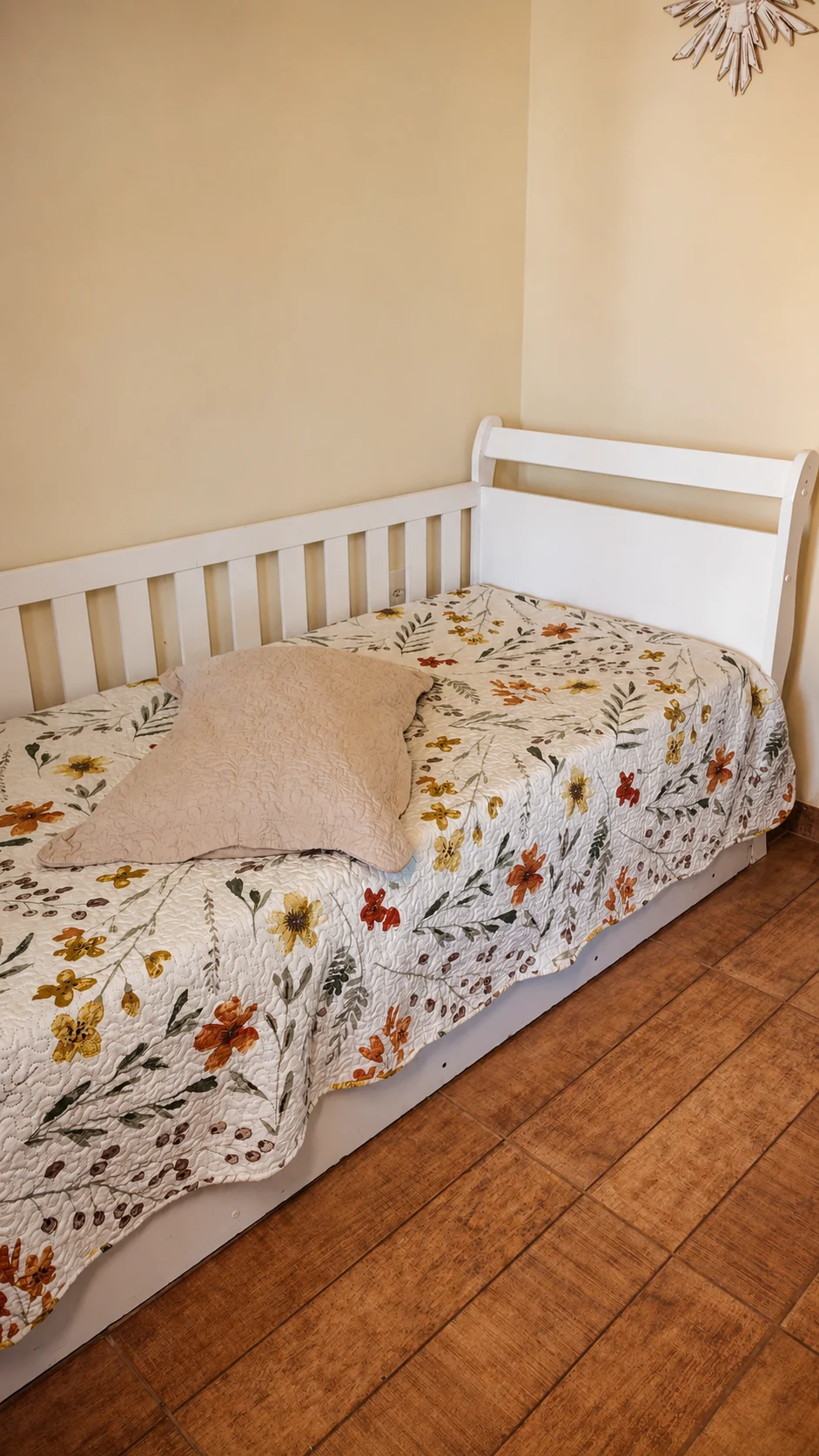 Cama de solteiro com roupa de cama floral em um chalé