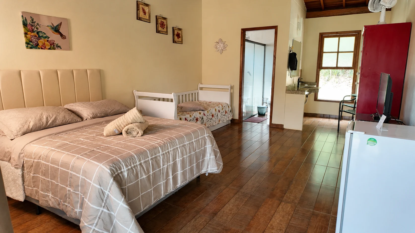 Quarto de chalé com cama, lareira e janela para o verde