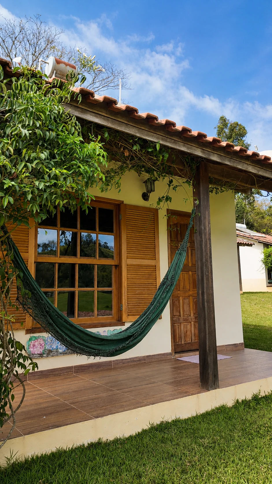 Varanda de chalé com rede voltada para o jardim