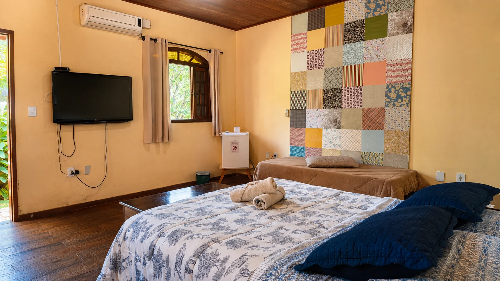 Quarto de chalé com cama azul, madeira e quadros